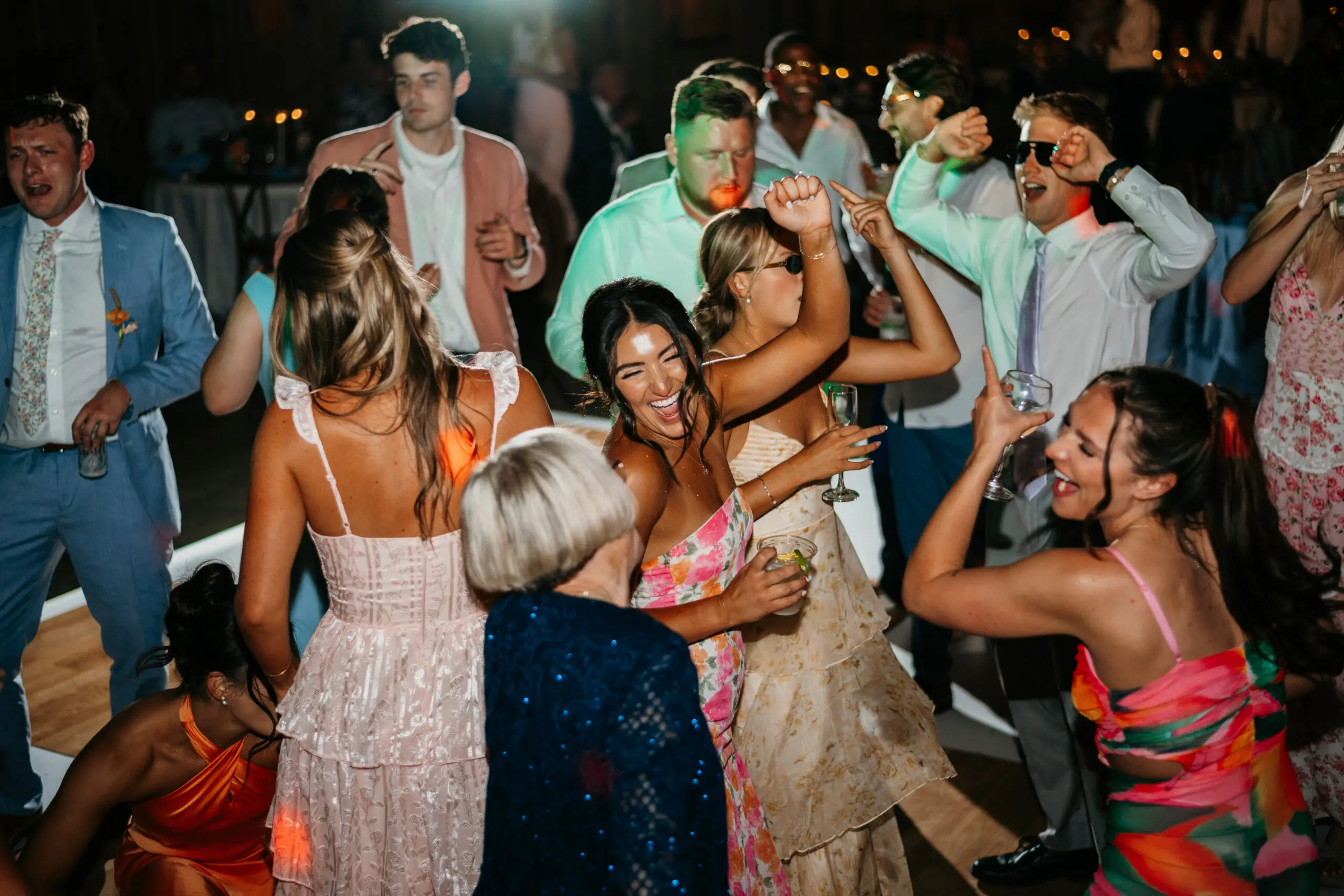 Packed wedding dance floor with guests celebrating